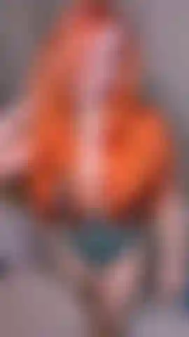 Eine freche rothaarige beugt sich für sie über ihren schreibtisch.