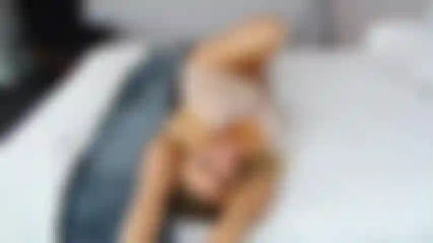 Babypuppenstreifen und spielzeug spielen auf dem bett.