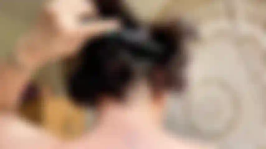 Die sich die haare kämmt und den kopf in nahaufnahme mit ohrringen kämmt.