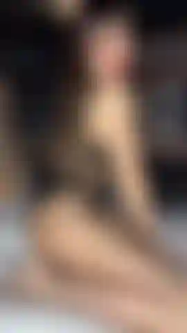Ein verführerischer body teaser in netzstrumpfhosen, ohne etwas darunter und mit roten lippen.