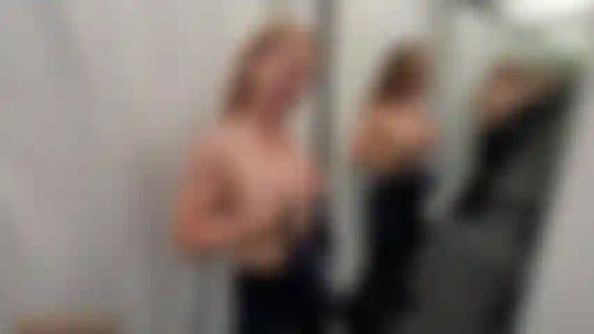 Probiere in einer umkleidekabine ein paar klamotten an.