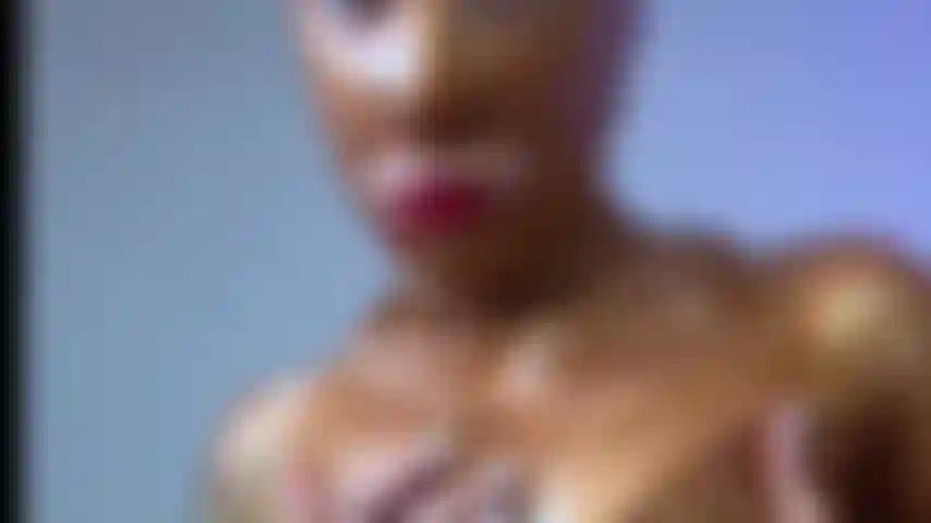 Ein neckischer goldener latex-catsuit mit freiliegender muschi.