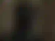 Eine versaute herrin mit latexkapuze, die deinen schwanz und deine brustwarzen neckt, während sie eine schwarz glänzende latexmaske trägt.