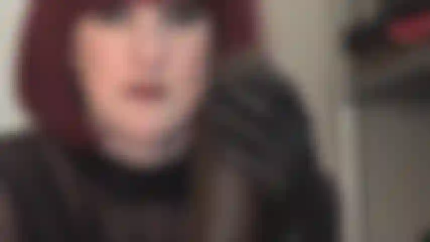 Streichle einen großen schwarzen schwanz mit lederhandschuhen.