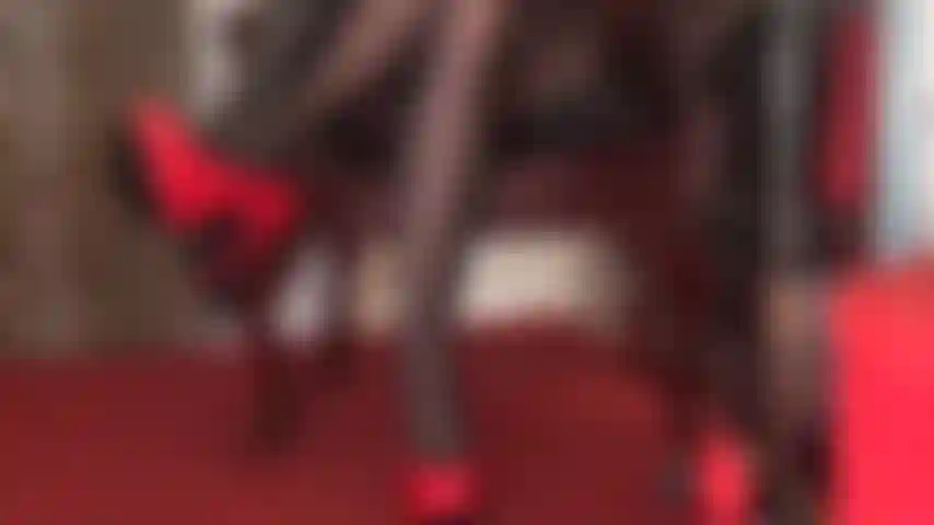 Glänzende rote stilettos, schwarze lederhandschuhe und schwarze strumpfhosenbeine sind pure verführung.