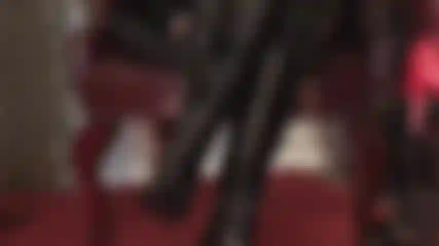 Pvc-liebhaber werden es genießen, der herrin dabei zuzusehen, wie sie glänzende vinylhandschuhe trägt und sanft über ihre glänzenden lacklederstiefel streicht.