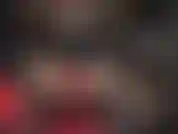 Rote lederhandschuhe an einem massiven schwarzen strapon.