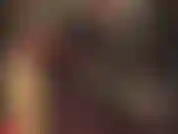 Hautenger schwarzer latex-catsuit und rote handschuhe.