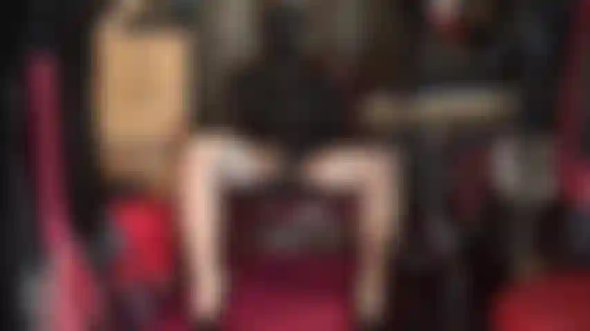 Streichle zwei riesige schwarze dildos – eine spandex-kapuze mit offenen augen, eine herrin-ledermütze, latexhandschuhe, glänzende strümpfe und strumpfhosen.