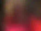 Sinnliches bein-teasen in einem sexy roten kleid und schwarzen strumpfhosen und peeptoes mit metallstilettos. Überkreuzte beine, fetisch für gestreckte beine, high heels.