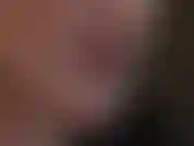 Nahaufnahme von gesicht, lippenstift und zungenreiz, während die herrin mit glänzenden roten latexhandschuhen neckt.