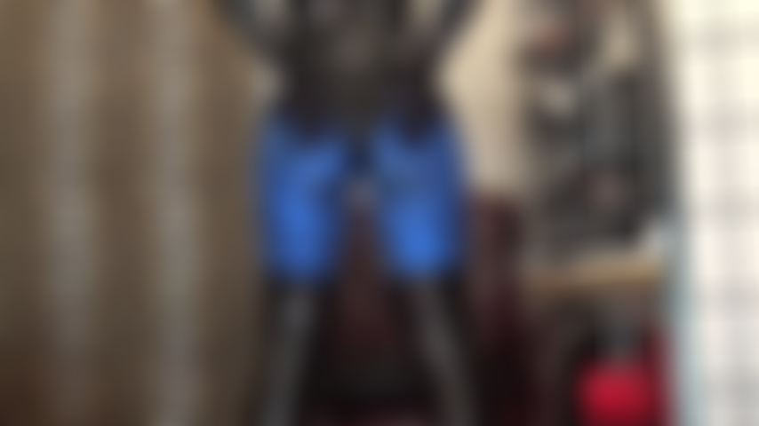 Ass in blue metallic lycra leggings and shiny pvc bodysuit, feet in dark brown pantyhose.