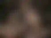 Eine ledergöttin mit sexy brille, die ihren riesigen weißen strap-on streichelt.