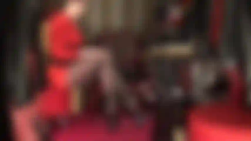 Diese langen beine sind deine schwäche – die göttin neckt mit einer seitenansicht ihrer erstaunlichen gekreuzten nylonbeine in hauchdünnen schwarzen strumpfhosen mit hohen riemchen-high-heels mit plateausohle.