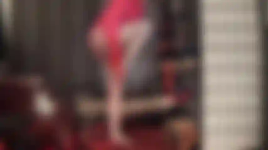 Verehre die sexy kurven der herrin in rot- und korallentönen – eine hübsche satinbluse mit rüschen, rote handschuhe, hüfthalter, strumpfhosen und strümpfe machen dich schwach.