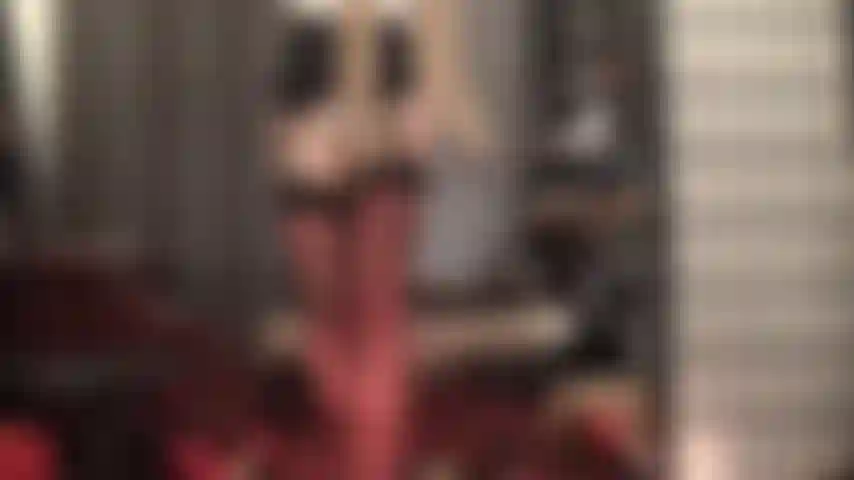 Eine glänzende strumpfhose über strümpfen und einem strumpfhalter für den ultimativen nylon-teaser.