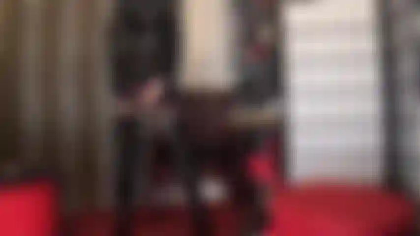 Eine lady in schwarz – arschverehrung in strümpfen, strumpfbändern, glänzendem pvc, stiefeln und hut.