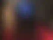 Die arschverehrung in blauen metallic-leggings, hohen schwarzen glänzenden stiefeln und einem weißen strapon dazwischen macht.