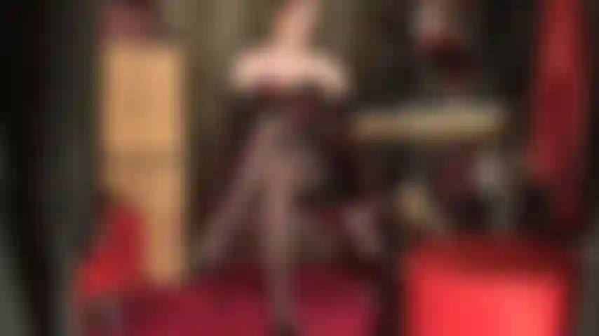 Lederhandschuhe, korsett und nylons – die herrin macht sie schwach und pulsierend wegen ihrer in strumpfhosen gekleideten, übereinandergeschlagenen beine, während sie sie sanft mit weichen lederhandschuhen streichelt.