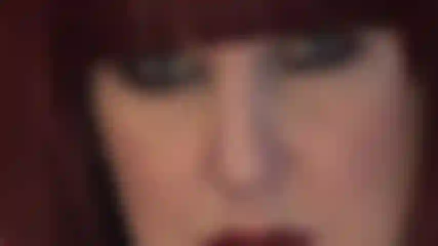 Das hypnotische gesicht der herrin – üppige rote lippen und durchdringende blaue augen, die direkt in ihre seele blicken.