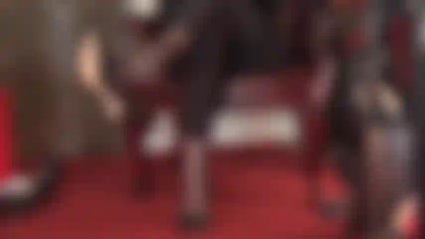 Sexy baumelnde neckerei, beine übereinandergeschlagen, schwarze lederschuhe, leggings und fußfetisch in 5-zehen-strumpfhosen.