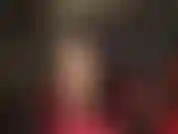 Sexy, hautfarbene strumpfhosen, bein-teaser, schwarze haare, schwarzes leder, roter body und rote stilettos mit knöchelriemen.