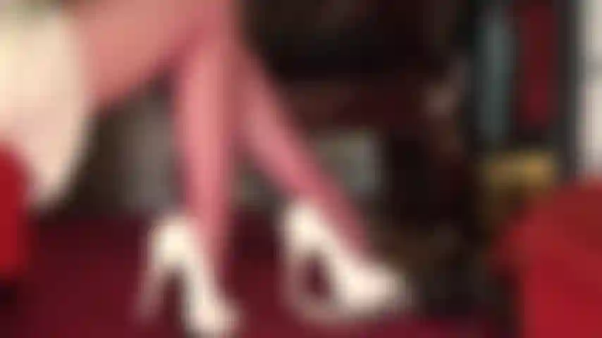 Schöne oberschenkel und beine in roten strumpfhosen mit blick unter den rock in einem hübschen satinrock.