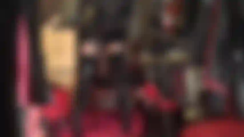 Facesitting im pvc- und nylon-bodysuit – hohe stiefel, glänzende strumpfhosen, pvc-rock und ein durchsichtiger nylon-bodysuit darunter.