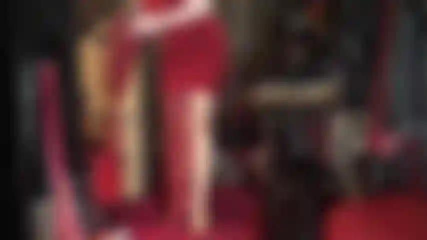 Die sich in leder kleidet – bewundern sie ihre göttin, die sich in lange lederstiefel, handschuhe und einen wunderschönen langen schwarzen mantel kleidet.