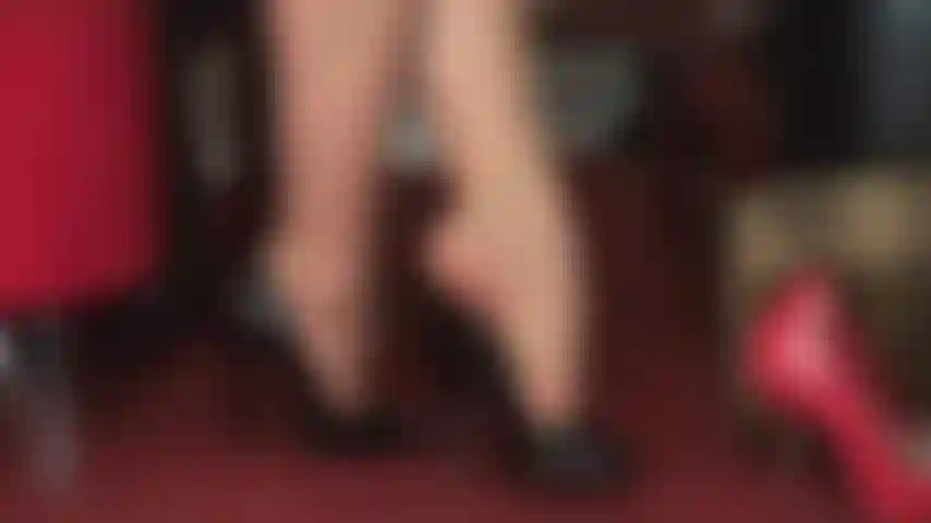 High heels in perfektion und fußfetisch – herrin vivian lässt glänzende schwarze peeptoe-pumps an ihren wunderschönen zehen in hellbraunen strumpfhosen baumeln.