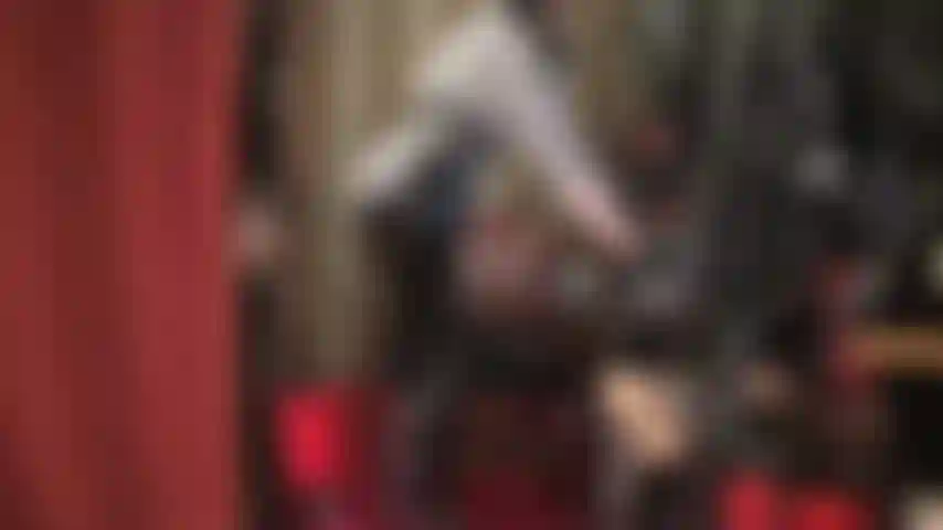 Glänzende schwarze lackhose – herrin frönt deinem fetisch für lackjeans und macht dich an, indem sie mit dem reißverschluss und den taschen spielt, den stoff leckt und küsst, in gestreifter bluse und langhaarperücke.