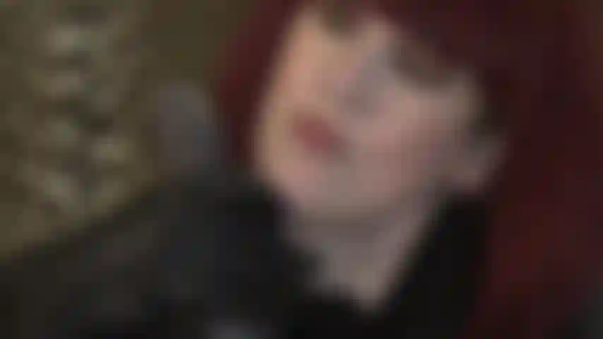 Eine ledergöttin, die einen großen schwarzen schwanz mit handschuhen streichelt.