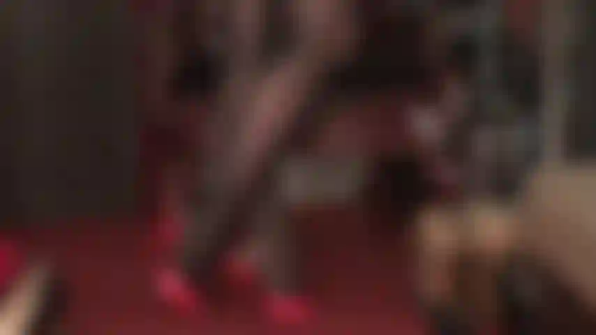 Extra glänzende schwarze strumpfhose mit ölglanz und rote pantoletten mit hohen absätzen.