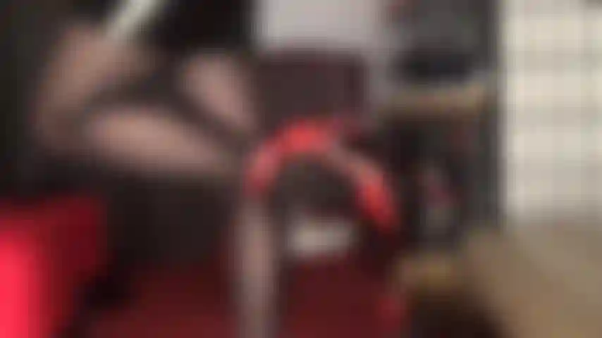 Genießen sie dieses bein-teaser in schwarzen, ölglänzenden strumpfhosen und roten lederpumps mit knöchelriemen.