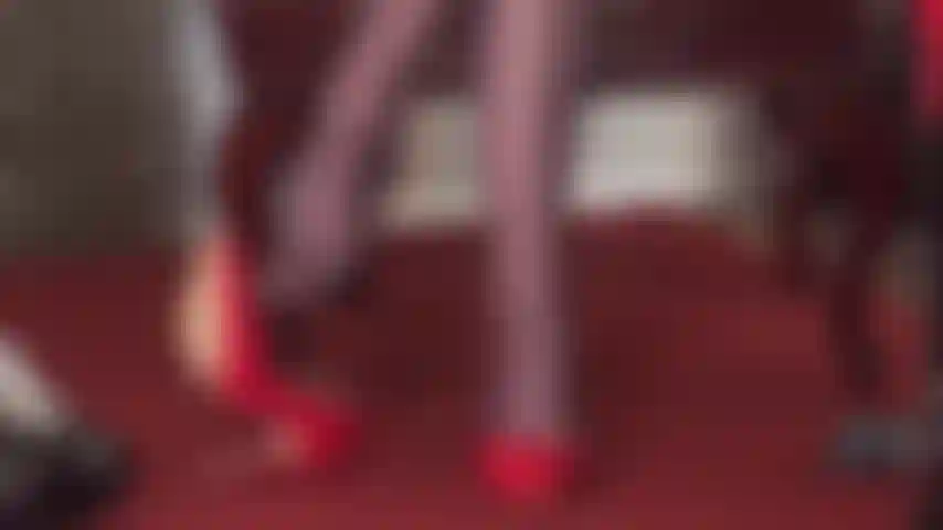 Herrin vivian zeigt ihre baumelnden fähigkeiten mit einem paar glänzender roter pumps und dunkelbrauner glänzender strumpfhose, reitgerte in der hand.