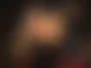 Eine herrin aus glänzendem pvc in stiefeln mit einem riesigen schwarzen strapon.