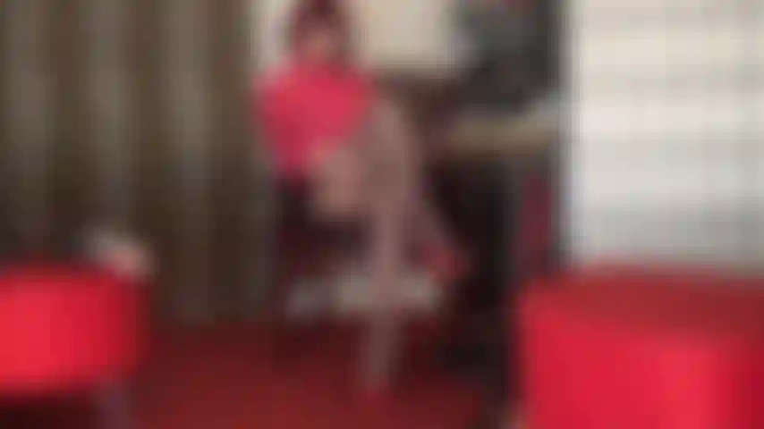 Herrin, der mit strumpfhosen bedeckte sklavenschwanz ist in der lücke zwischen den überkreuzten strumpfhosenschenkeln gefangen.