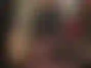 Ihre nylongöttin neckt mit ihren beinen, ihrem hintern und ihren füßen in seidigen, durchsichtigen schwarzen strumpfhosen und trägt einen glänzenden pvc-bodysuit.