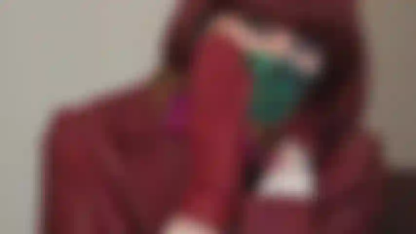 Seidenschal-maskenfetisch – ein weicher seidenschal kann sehr effektiv als maske oder knebel verwendet werden. Herrin ist in rotes leder gekleidet und trägt einen bunten seidenschal, um den mund zu bedecken.