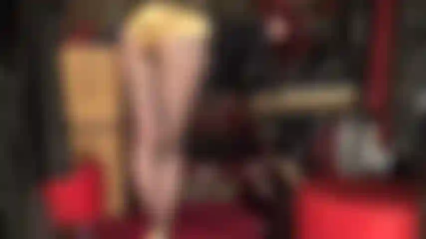 Herrin vivian beugt sich über ihren tisch, blickt zurück und neckt mit ihrem perfekten hintern in glänzenden goldenen satinshorts.