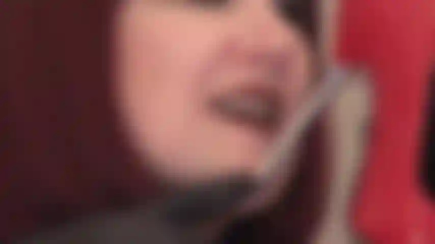 Schwarze lederhandschuhe, lippenstiftlippen und zunge auf glänzenden metall-stiletto-pumps.