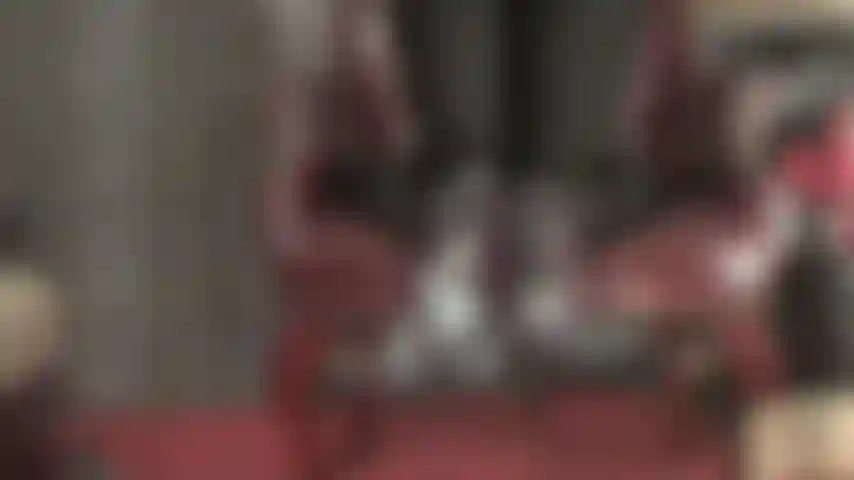 Herrin zieht ihre absätze aus, ihre füße in den hauchdünnen strumpfhosen baumeln vom stuhl.