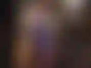 Ihre latexgöttin präsentiert ein sexy outfit mit oberteil und hinterem spitzenrock aus metallisch glänzendem lila gummi.