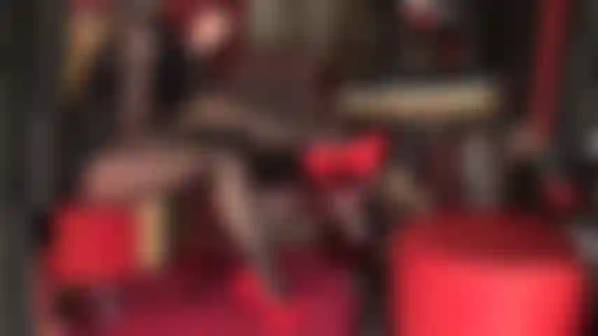 Spiele mit beinen in schwarzen, glänzenden strumpfhosen, leder und roten stilettos. Überkreuzte beine, schwarzer lippenstift, heiße rote absätze.