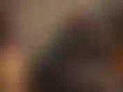 Eine latexgöttin im engen gummi-catsuit, deren schwarzer strapon für das harte pegging, das sie verdienen, geschmiert wird.