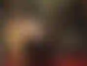 Eine schwarze perücke und ein glänzendes fetisch-outfit aus pvc/vinyl mit hohen stiefeln und einem riesigen strapon für hartes pegging.