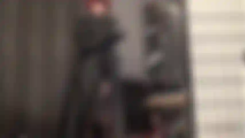 Eine bbc-strapon-lederherrin – die herrin bringt ihren kopf zum drehen, während sie ihren riesigen schwarzen schwanz unter ihrem langen schwarzen ledermantel, den handschuhen und den sinnlichen strapsstrümpfen wichst.