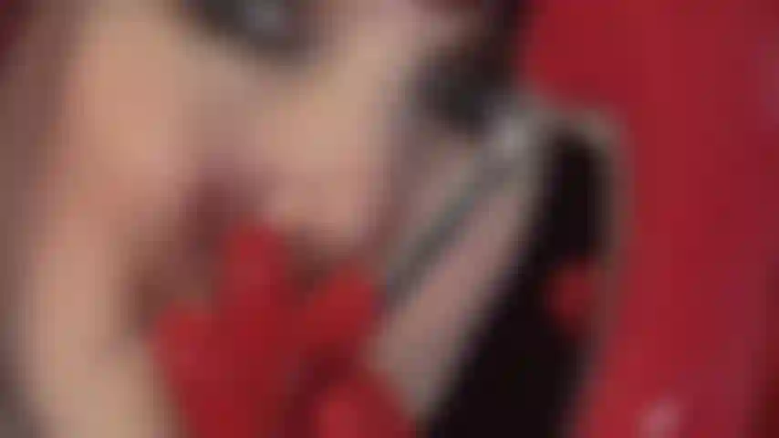 Trage versaute rote latex-fetischhandschuhe, rote lackpumps mit stahlabsatz und necke mit einem schwarzen schwanz.