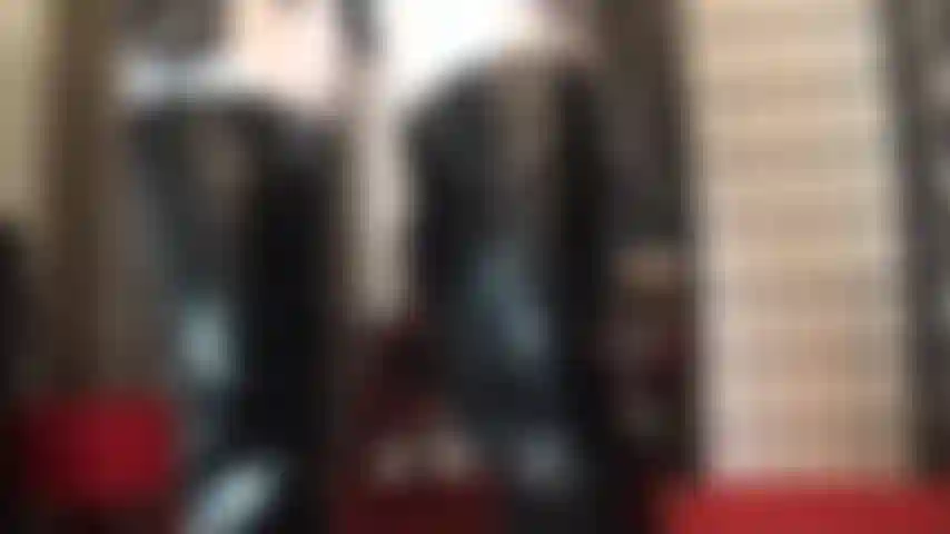 Schwarz-weißes outfit aus glänzenden fetischstiefeln und handschuhen aus pvc, gepaart mit weißen glänzenden lycra-strumpfhosen.