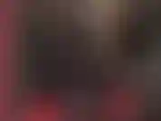 Eine versaute latex-fetisch-göttin im schwarzen gummi-catsuit mit kapuze und bbc-strapon.